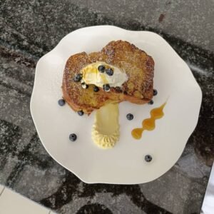 French toast with white ganache and honey glazed with fresh blueberries